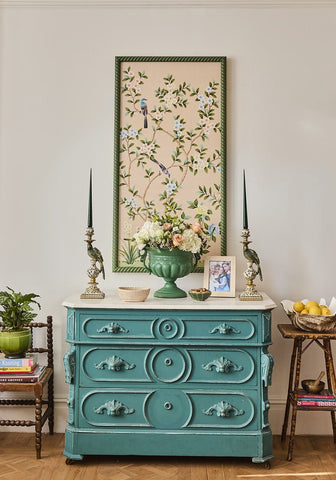 Teal-painted antique-style dresser with ornate carved handles paired with green aurora slender taper candles