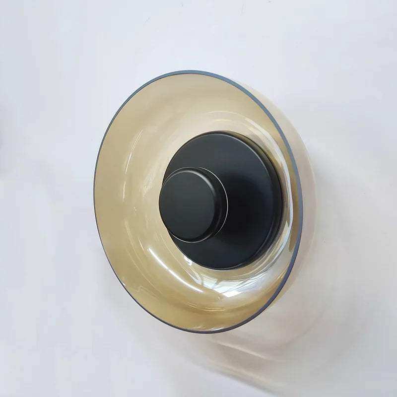 A sleek aurora wall lamp with amber glass bowl and matte black base perfect for stylish wall lighting