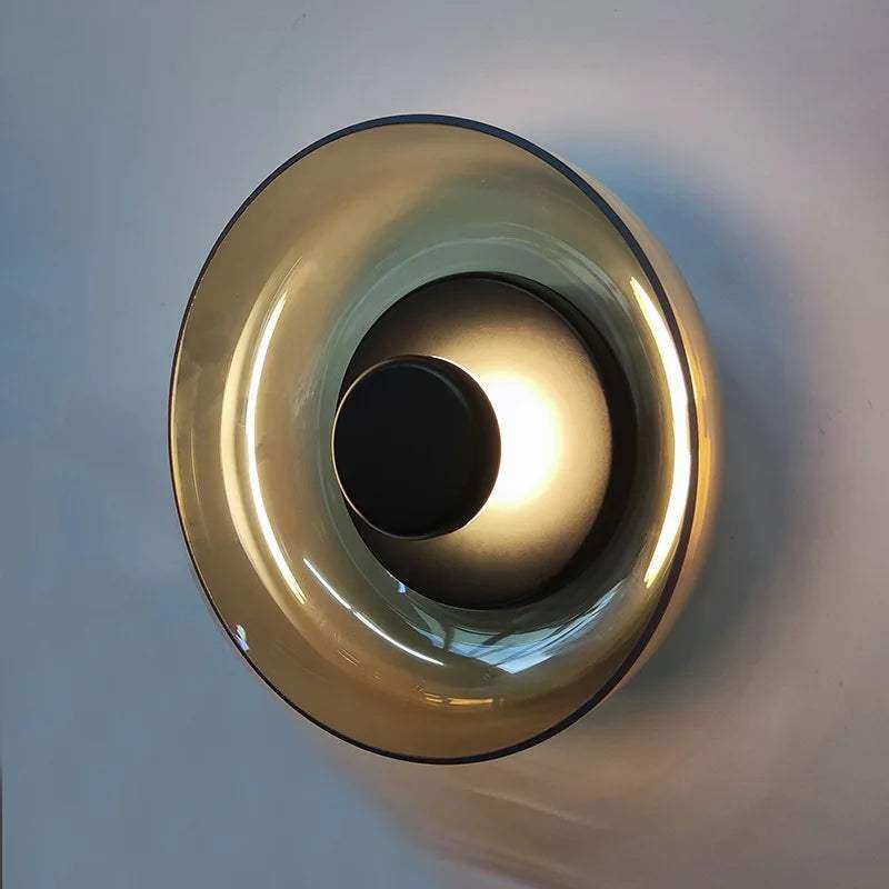 A sleek amber-tinted glass aurora wall lamp with a modern concentric circular design for stylish lighting