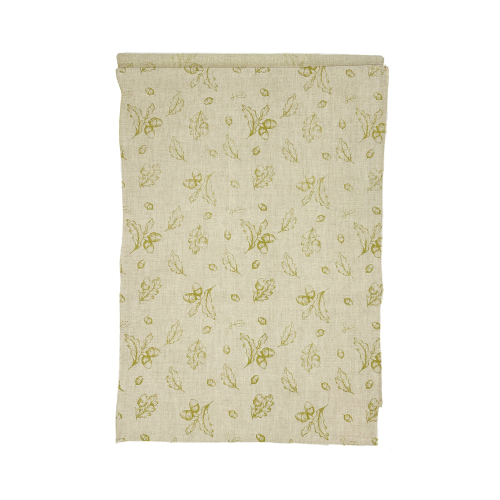Folded autumn acorns linen table runner with olive green leaf and acorn pattern on off white linen table cloth