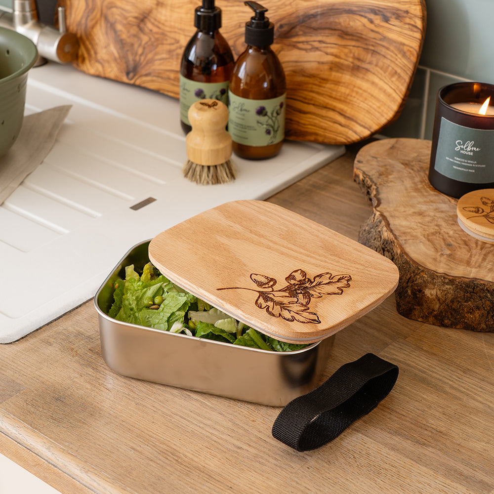 Rectangular stainless steel lunch box with a light wood lid engraved with leaf and acorn design autumn acorns lunch box