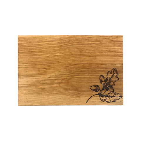 Light brown oak serving board with dark engraved leaf design perfect for autumn acorns cheese serving