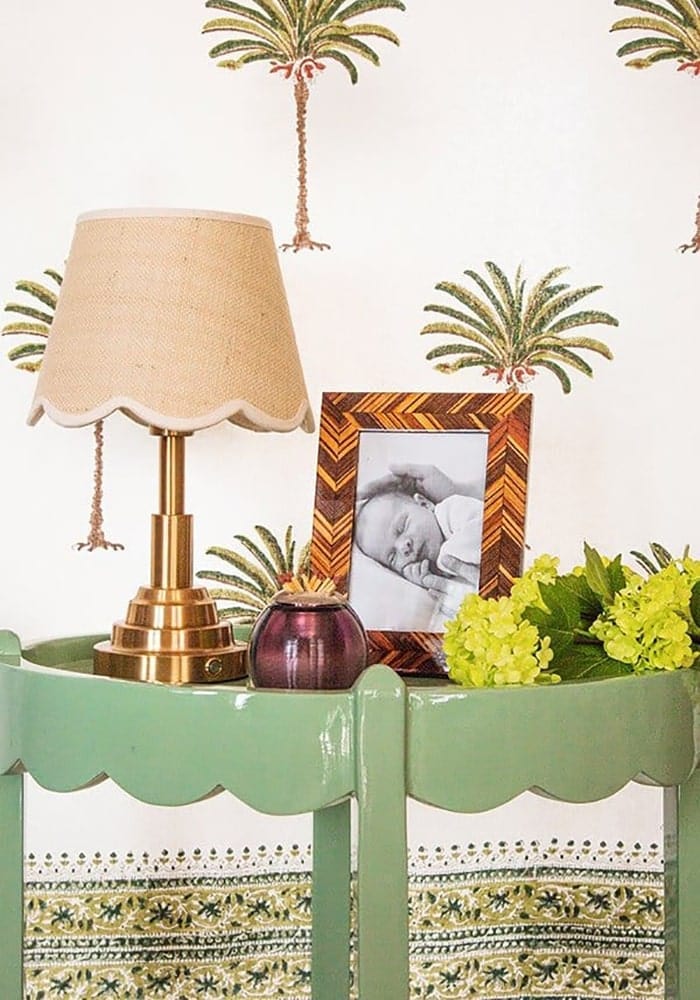 A brass table lamp with a beige scalloped fabric shade next to an autumn bark photo frame 6x4 inches