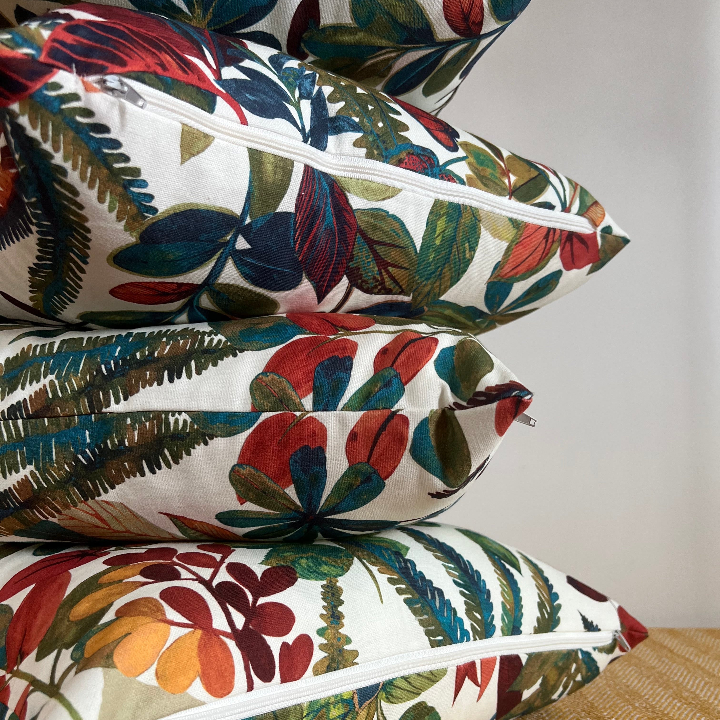 Stacked autumn leaves cotton throw cushions with vibrant red green and blue tropical leaf patterns and zipper closures