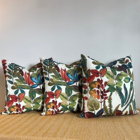 Three rectangular cotton throw cushions with vibrant autumn leaves cotton print in red blue green and orange on white