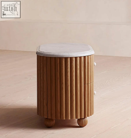 A sleek wooden bedside table with vertical fluted panels and a white marble top in rounded rectangle style