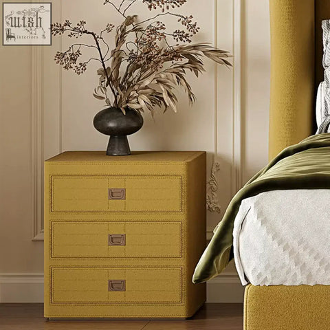Mustard-yellow textured leather aveline bedside table with three drawers and metallic handles for stylish storage