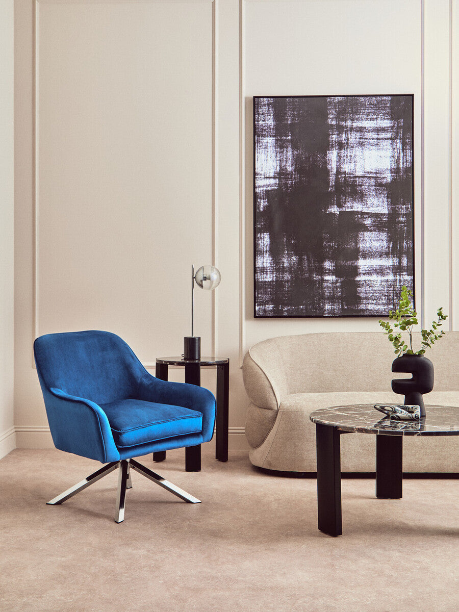 A vibrant blue midnight velvet swivel chair with a sleek chrome base perfect for stylish seating