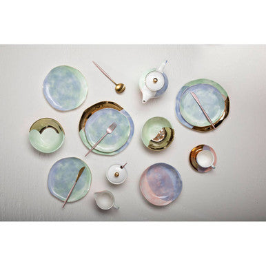 A set of delicate ceramic plates with iridescent glaze paired with the avie 16 piece matte pink finish cutlery set