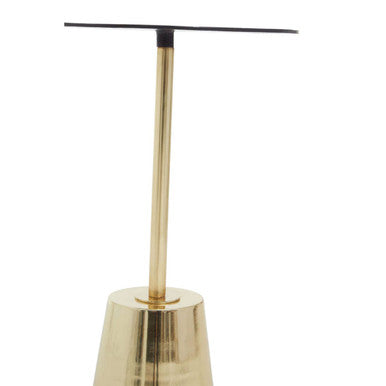 Gold-colored metal earring stand with sleek tapered design and black-tipped top near black marble effect side table with gold base