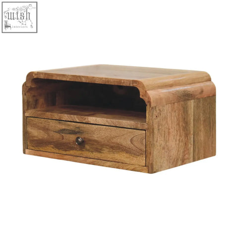 A rustic avora wall mounted bedside table in natural mango wood with a curved top drawer and open shelf