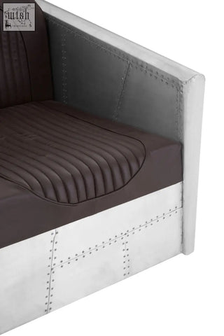 Avro armchair with dark brown faux leather quilted seat and silver metal panels with rivet accents
