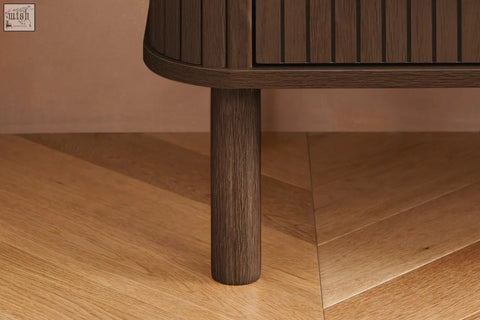 Dark brown wooden leg with vertical grain and rounded top edge on axel 6 drawer chest from fluted bedroom range