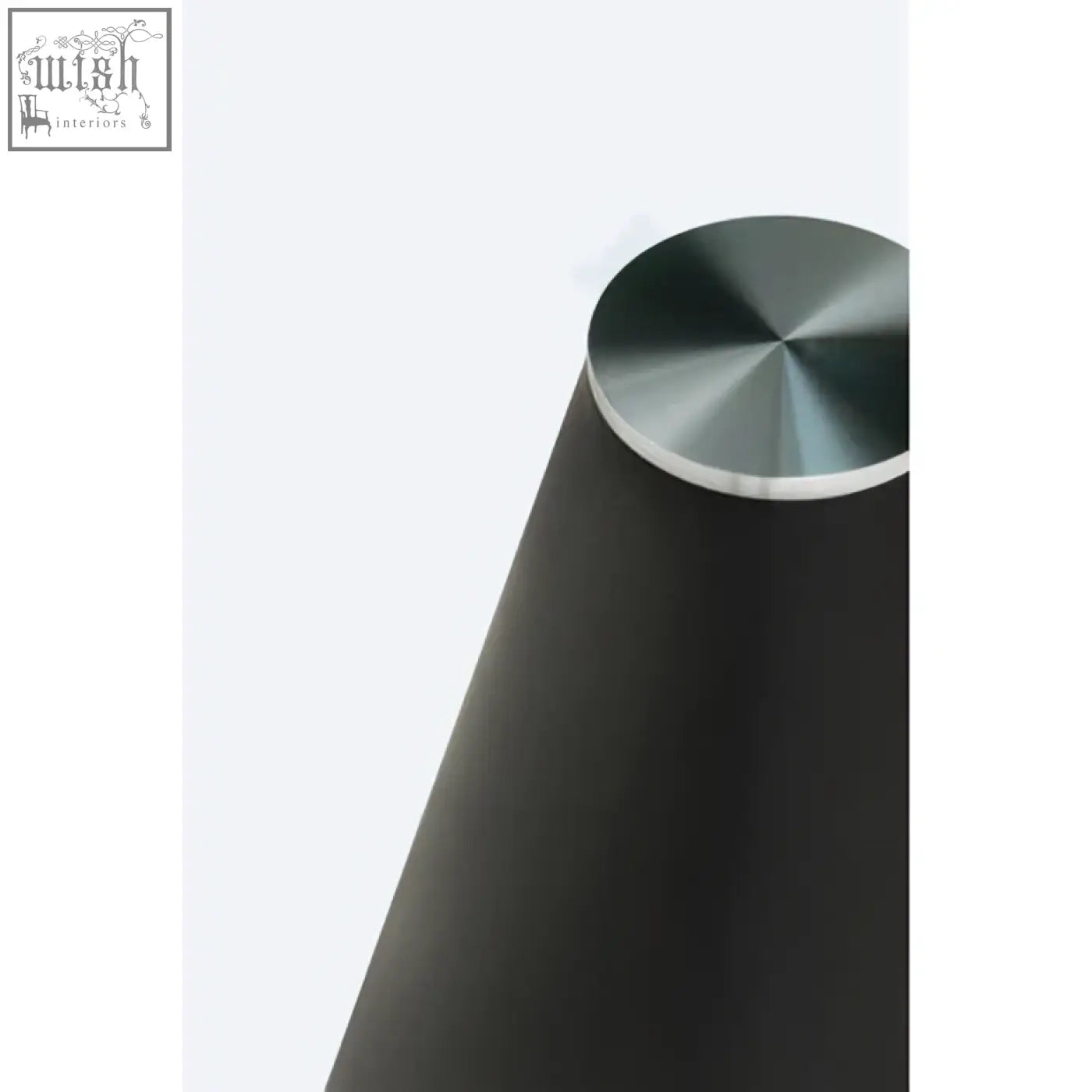 Black conical speaker with brushed metallic top placed on an azalea round clear glass dining table