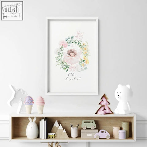 A framed watercolor wall art print for baby’s room with a delicate ballerina and pink yellow flower wreath with olivia sleeps here text