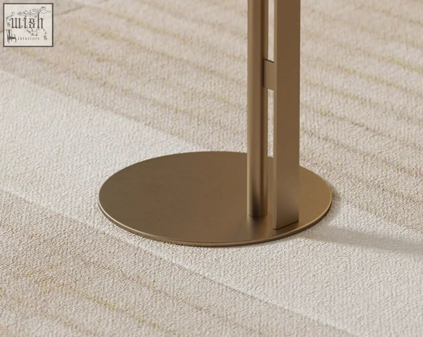 A sleek minimalist floor lamp with brushed gold metal base standing next to the bagley coffee table stainless steel