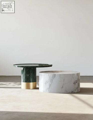 Two minimalist bain coffee tables featuring dark green marble with gold base and white marble tops in a table set