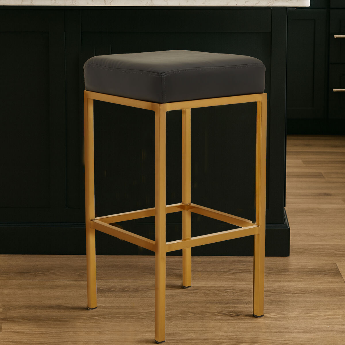 A modern baina black finish bar stool with dark gray upholstered seat and polished gold finish bar frame