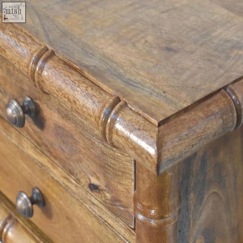 A rustic wooden bamboo bedside dresser in warm amber oak finish with turned bamboo-style legs