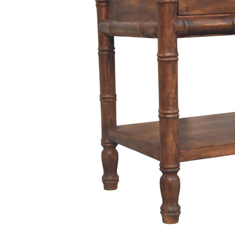 Dark brown bedside table with bamboo style legs and lower shelf made of solid mango wood and brass accents