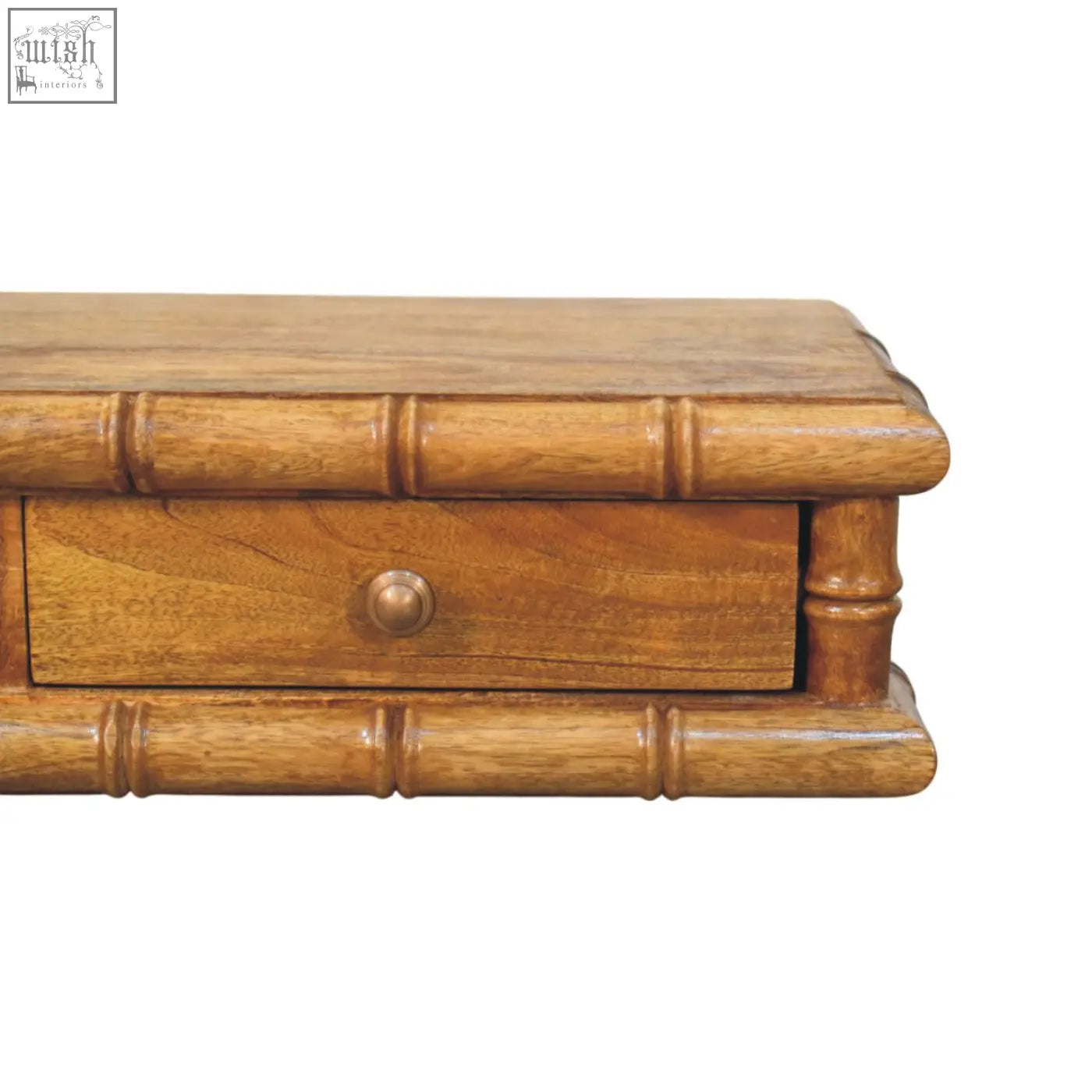 Light brown bamboo wall-mounted console with vertical grooves and single drawer with round brass knob on wooden desk