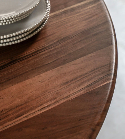 Bardo round dining table with rich dark brown wood and polished smooth finish showing natural grain patterns
