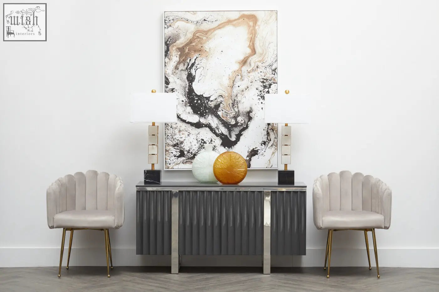 Gray ribbed console table with gold-tone legs and two lamps beside stylish mink velvet scalloped dining chair