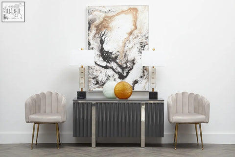Gray ribbed console table with gold-tone legs and two lamps beside stylish mink velvet scalloped dining chair