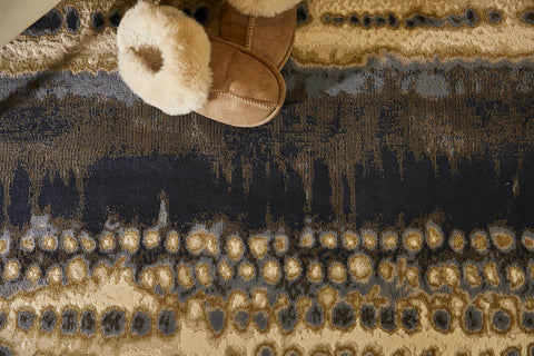 Tan suede slip-on boot with plush cream faux fur cuff styled on a batik multicolour abstract rug