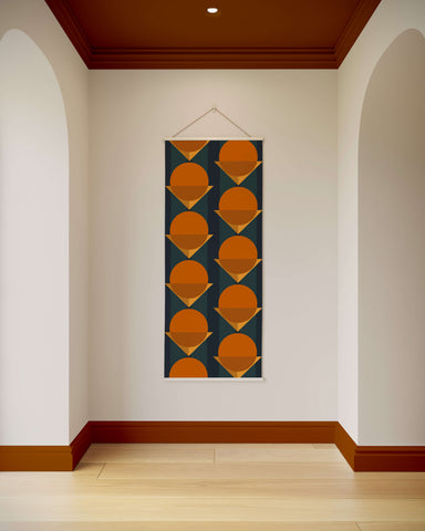 A bauhaus geometric tapestry wall hanging with orange circles and gold triangles on a dark teal background