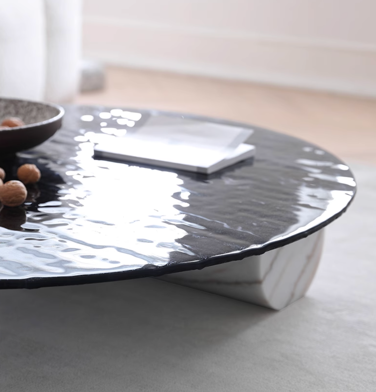 Black glossy ceramic baxter coffee table with textured wave top and white marble legs for stylish living rooms