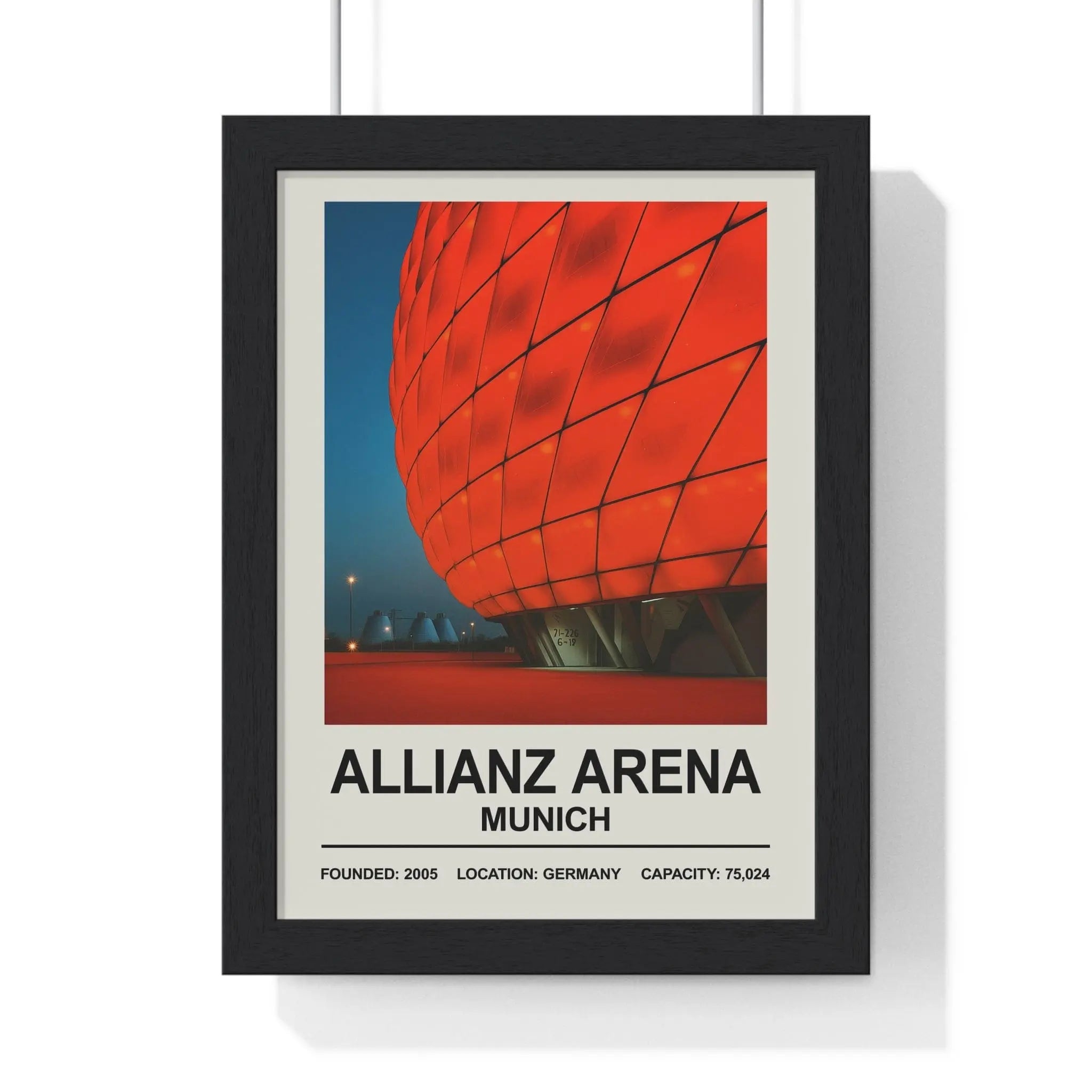 Black-framed poster of vibrant red geometrically patterned allianz arena in munich against deep blue sky bayern munich print
