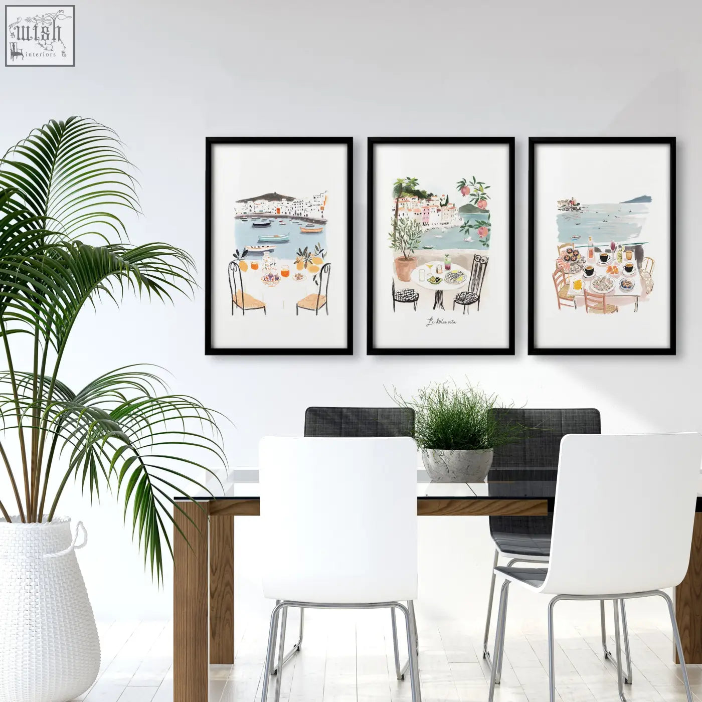 Three black-framed watercolor beach art prints of coastal dining scenes hanging above a wooden dining room table