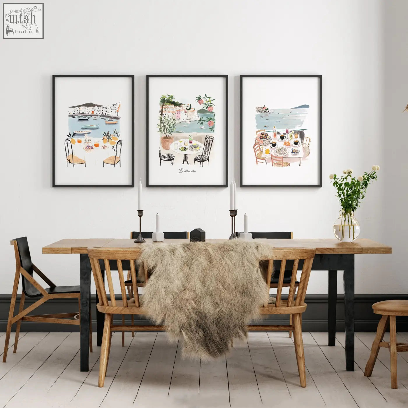 Three framed beach art prints of coastal mediterranean dining scenes hang above a wooden dining room table wall art set