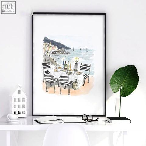 Black-framed watercolor beach artwork of amalfi coast seaside dining scene with striped chairs solo di amalfi