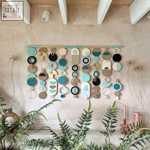 A modern wall art wooden geometric artwork with teal black beige and white discs perfect for minimalist decor
