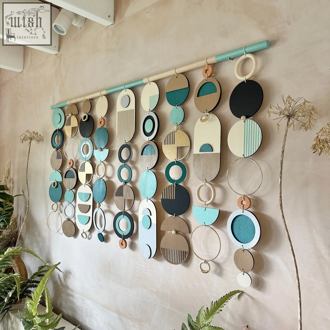 A modern wall art wooden geometric artwork with layered teal black beige and cream circles and ovals for minimalist decor