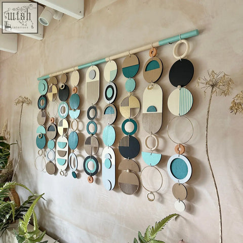 A modern wall art wooden geometric artwork with layered teal black beige and cream circles and ovals for minimalist decor