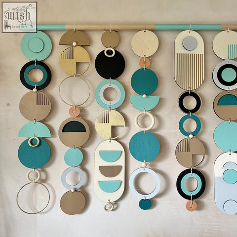 A modern wall art wooden geometric piece with layered teal black beige white and gold circles for minimalist home decor