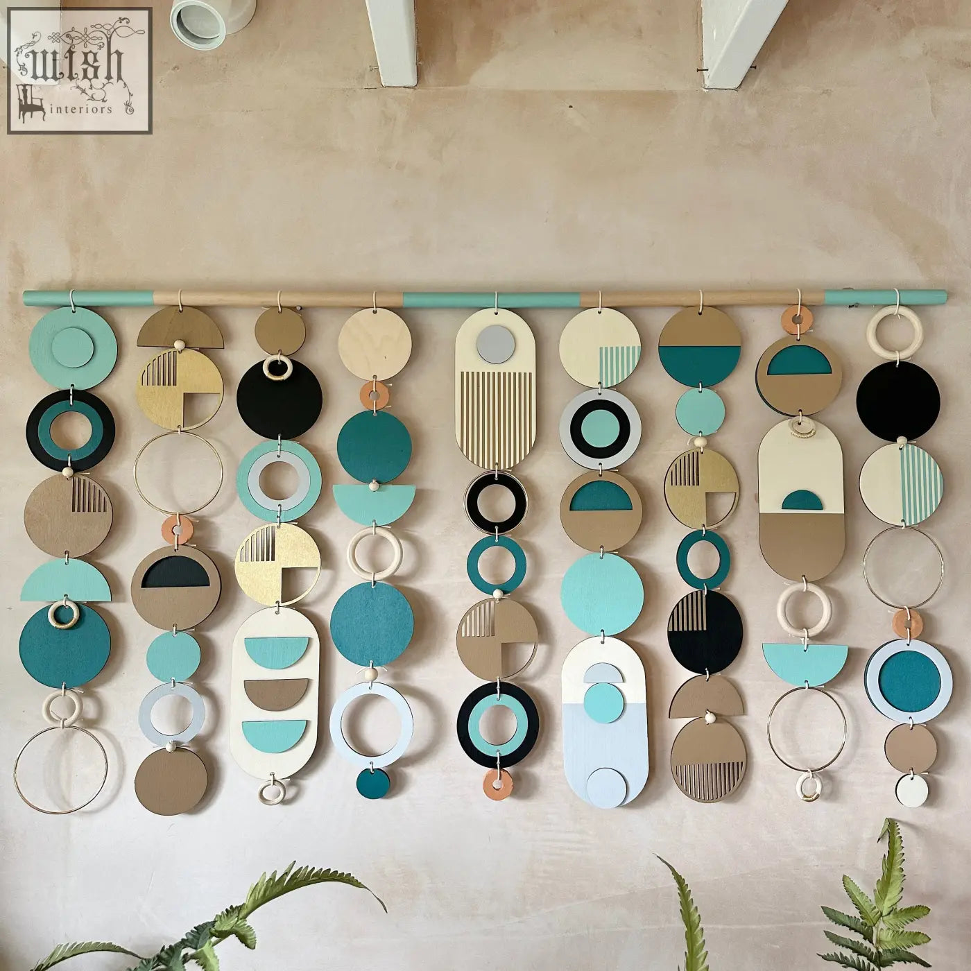 A modern wall art wooden geometric piece with teal black beige and white layered circles for minimal home decor