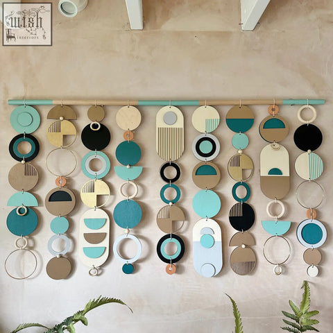 A modern wall art wooden geometric piece with teal black beige and white layered circles for minimal home decor