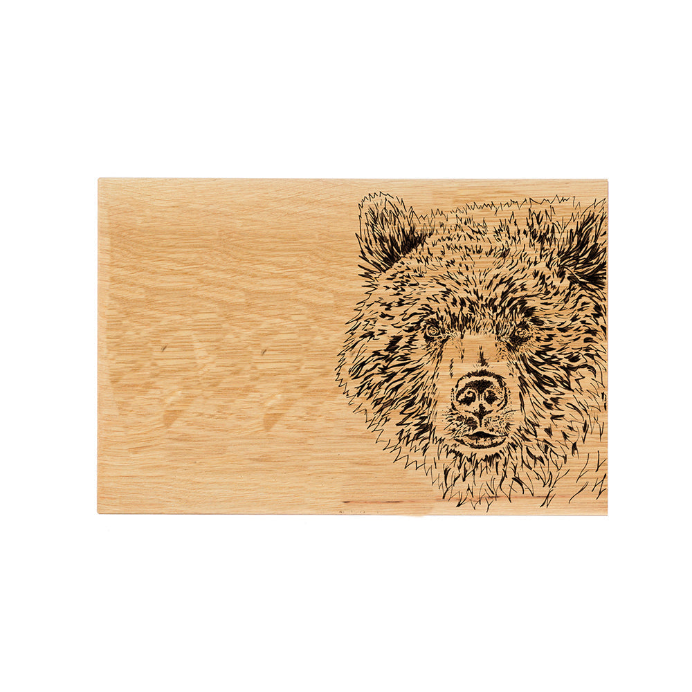 A light brown oak serving board with a detailed black burned bear oak illustration perfect for cheese and snacks