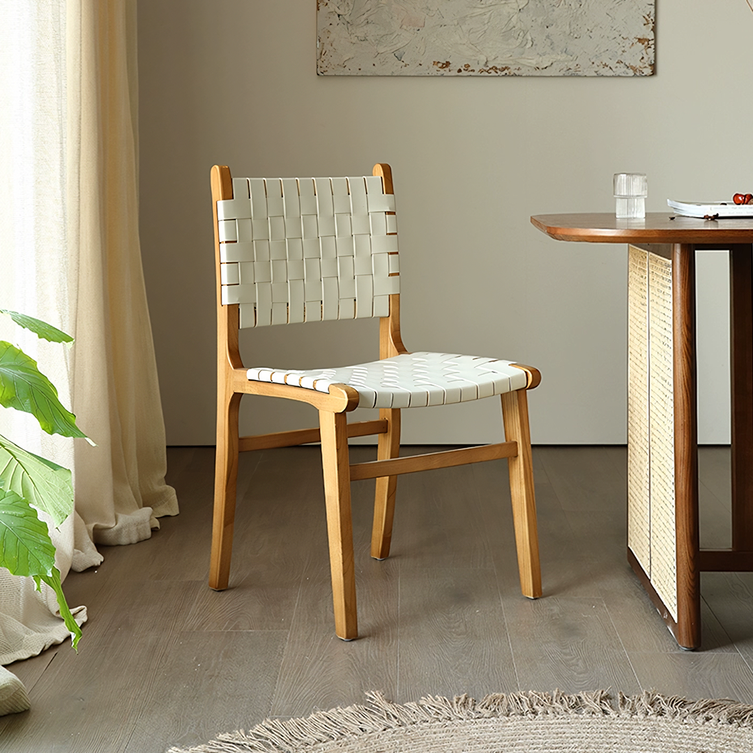 A minimalist dining chair with a woven white leather seat and backrest made of ash wood without armrest