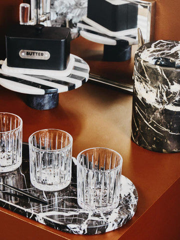 Three clear ribbed crystal large tumblers from the beaufort set arranged on a black and white marble tray