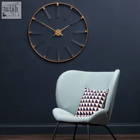Beauly gold finish round wall clock with a gold-toned metal frame and minimalist black rectangular hour markers