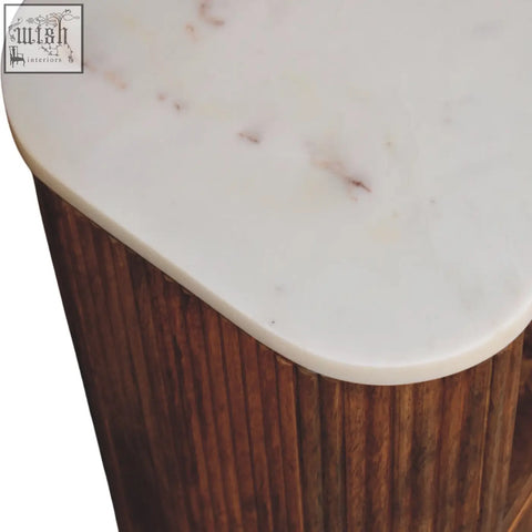 A beaumont marble bedside table with a sleek oval marble top and a solid mango wood base in dark finish