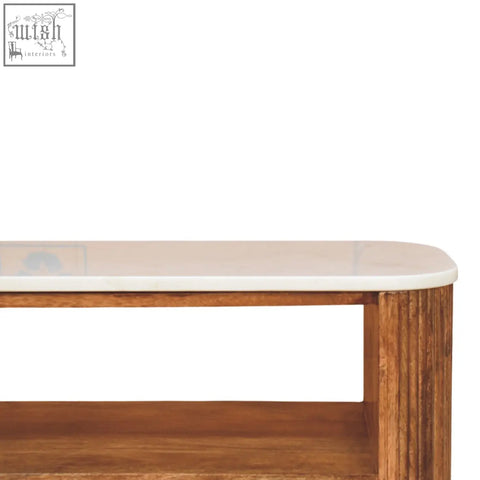 A sleek oval beaumont marble shoe bench with a white marble top and solid mango wood textured legs