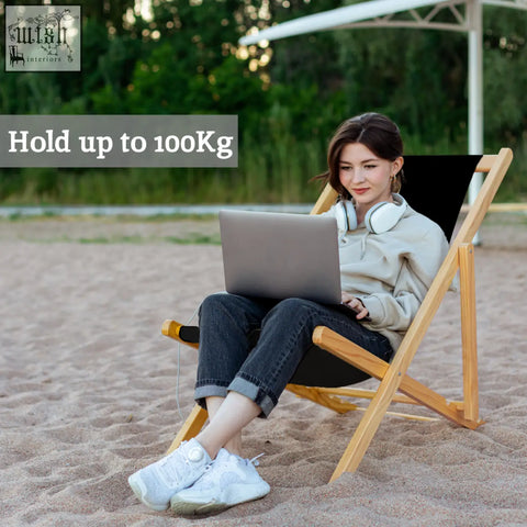 Beauport black deck chair with beige hoodie and rolled-up cuffs paired with dark blue jeans on black deck