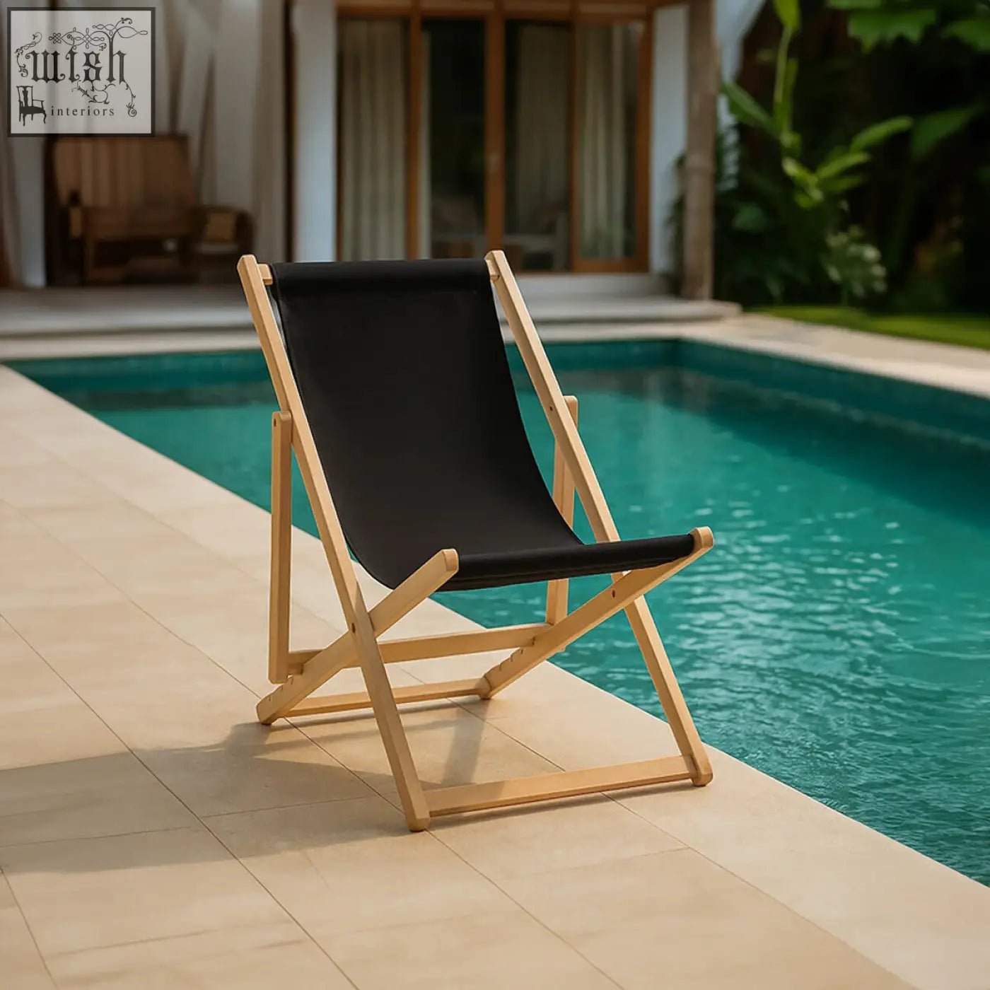 Black deck chair with light wood frame made of canvas fabric placed poolside perfect for outdoor lounging