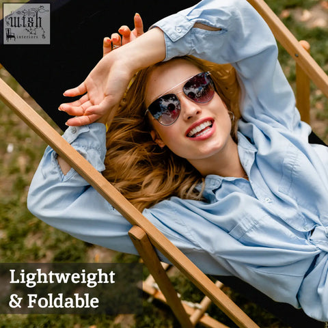 A pair of sleek metallic aviator sunglasses with reflective lenses resting on a black deck chair